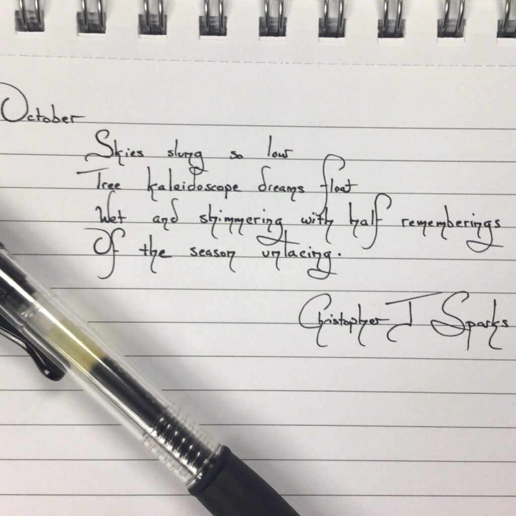 Handwritten poem on a notebook, pen sitting on top.
